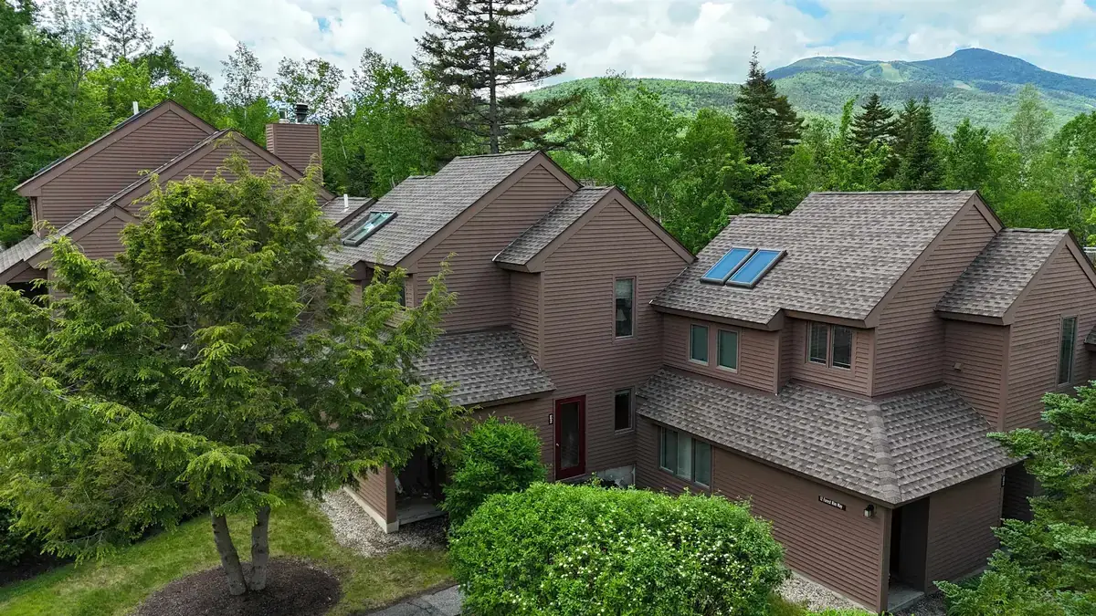 Condominium townhouses in Waterville Valley with ski trails visible on the mountainside behind them
